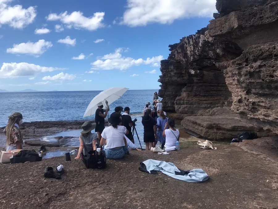 Crew setting up a shot on a rocky shoreline