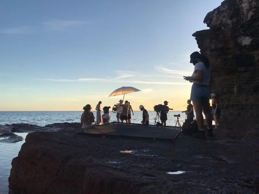 A crew shooting on the rocks at sunset