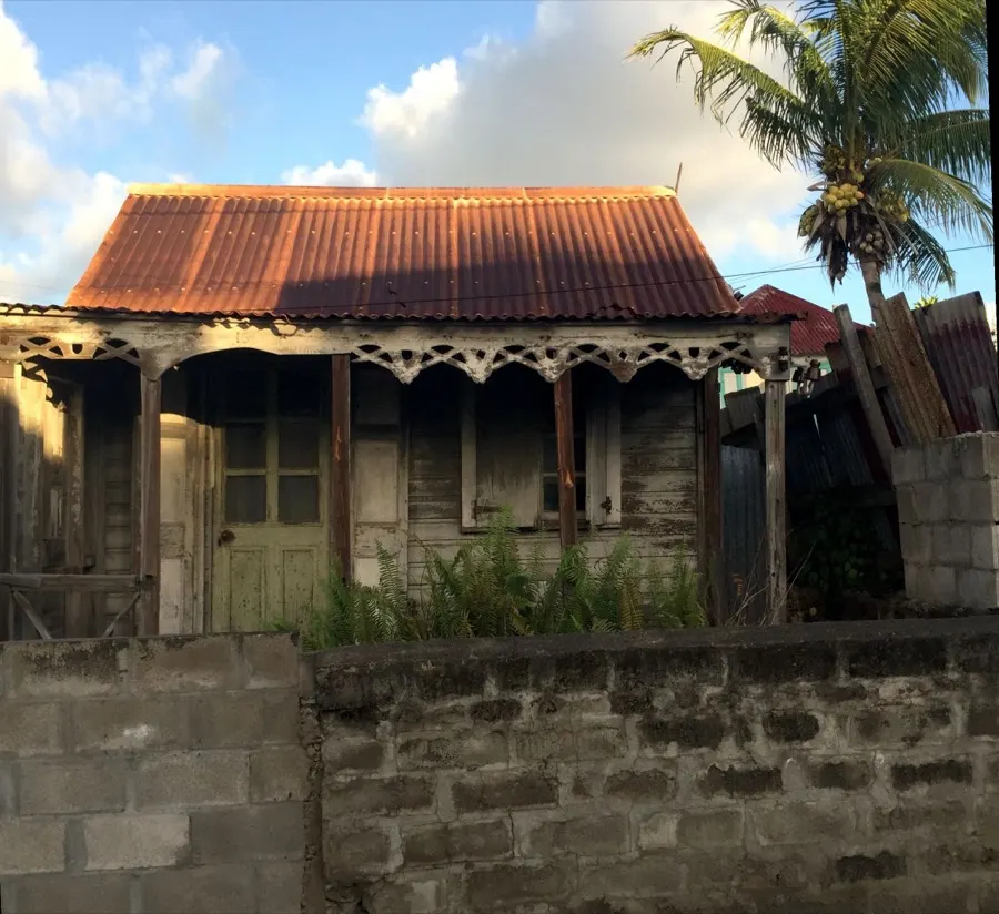 A wooden gingerbread cottage with a rusted roof