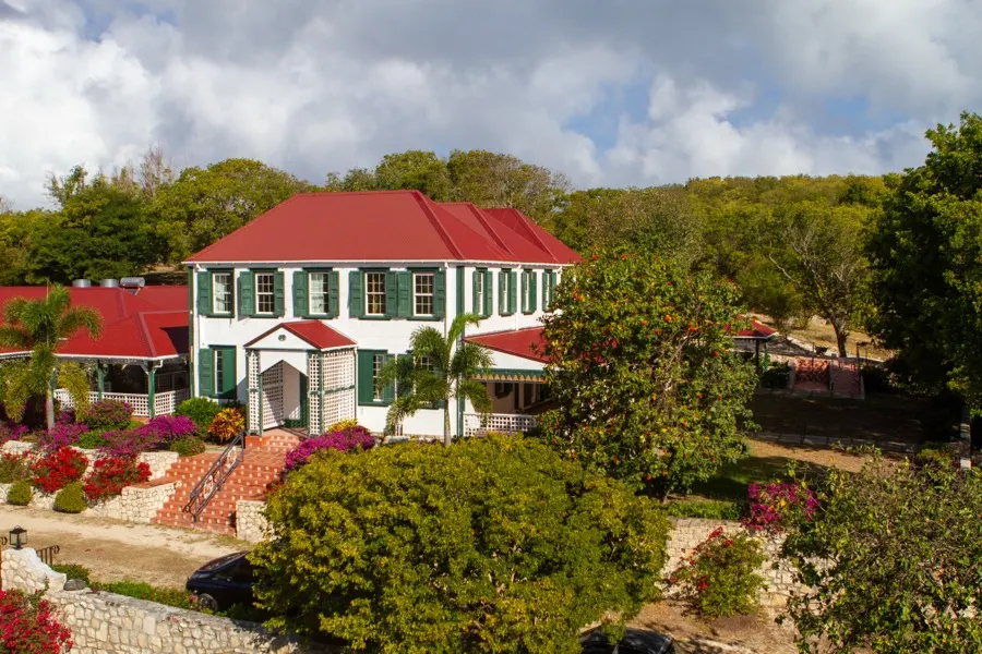 A red-roofed plantation house among gardens