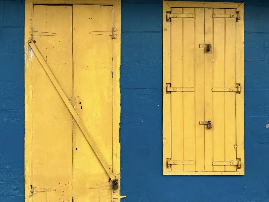 Yellow shutters on a blue wall