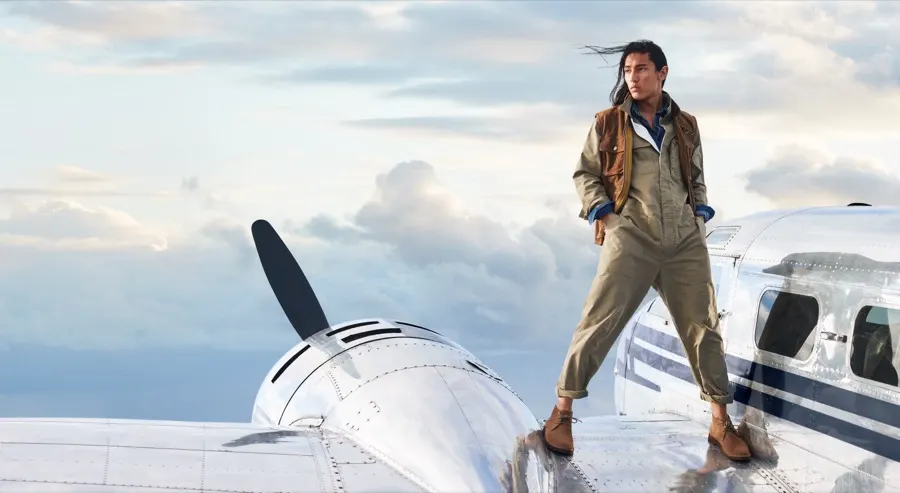 Model standing on the wing of a vintage aircraft