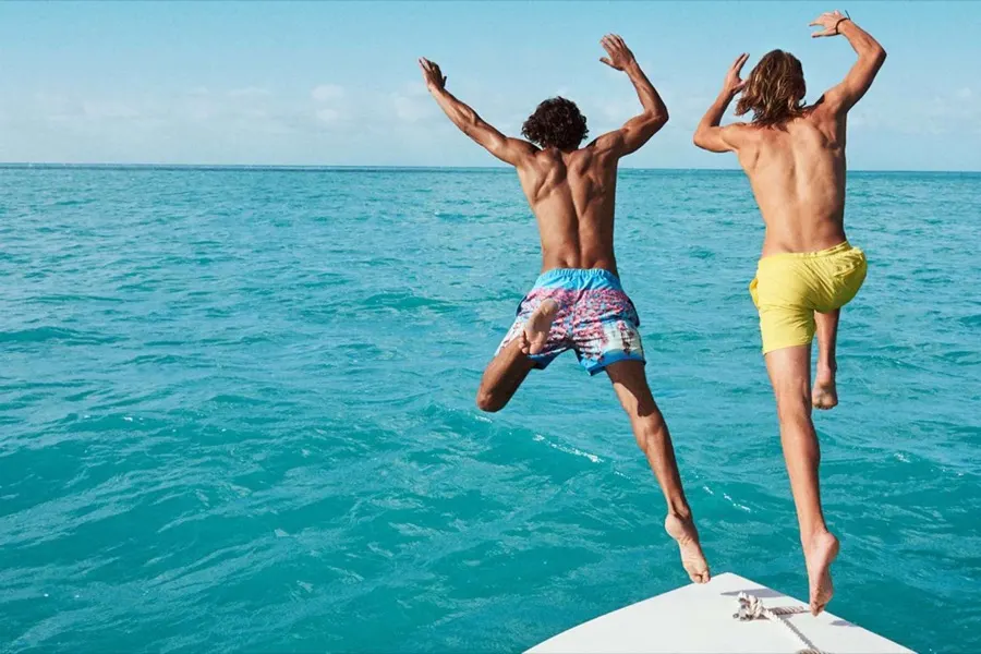 Two models jumping off a boat into the sea