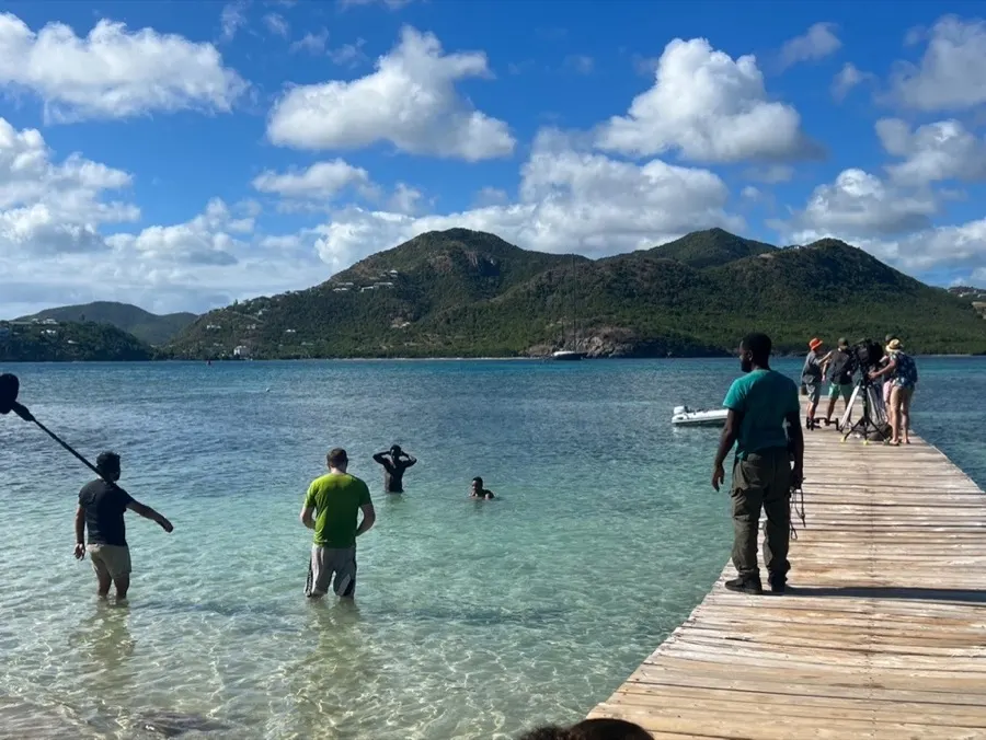 Sound crew in the shallows beside a jetty