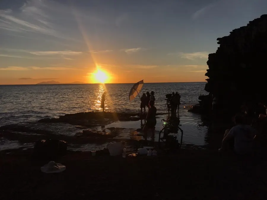 Behind the scenes: crew on the rocks at golden hour